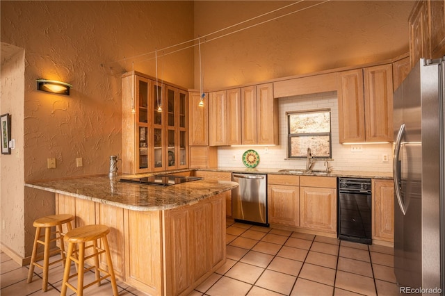 kitchen featuring sink, appliances with stainless steel finishes, backsplash, a kitchen breakfast bar, and kitchen peninsula