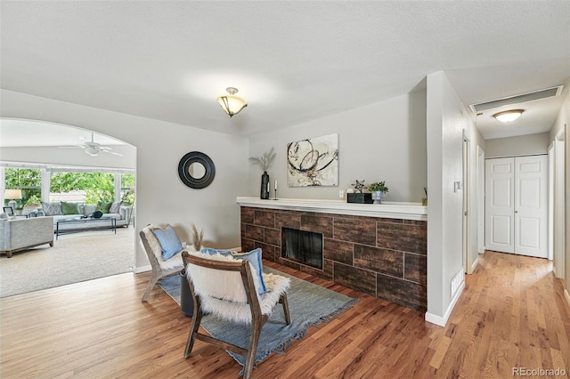 3570 E Arapahoe Pl, Centennial, CO 80122 - living area with wood finished floors, a tiled fireplace, baseboards, and a ceiling fan