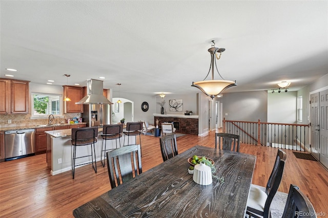 3570 E Arapahoe Pl, Centennial, CO 80122 - dining room with light wood finished floors, arched walkways, a fireplace, and recessed lighting
