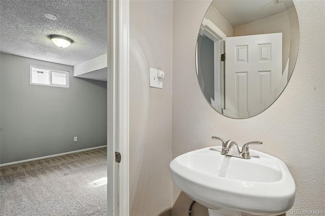 3570 E Arapahoe Pl, Centennial, CO 80122 - bathroom featuring a sink, a textured ceiling, and baseboards