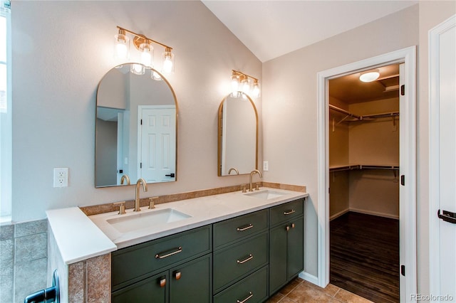 5597 S Buchanan St, Aurora, CO 80016 - full bathroom with double vanity, lofted ceiling, a walk in closet, and tile patterned floors