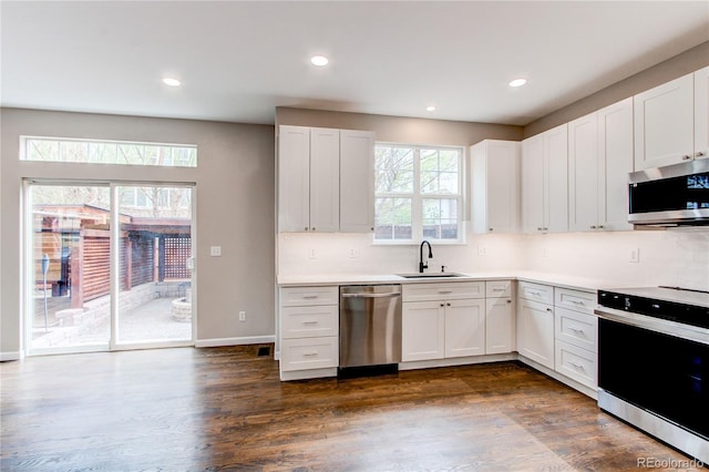 5597 S Buchanan St, Aurora, CO 80016 - kitchen featuring appliances with stainless steel finishes, a sink, white cabinets, light countertops, and recessed lighting