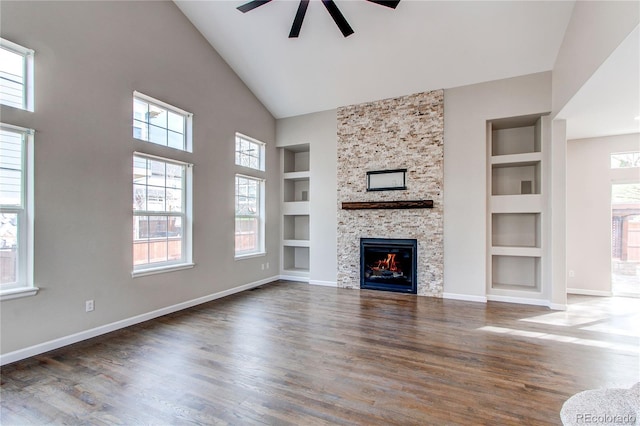 5597 S Buchanan St, Aurora, CO 80016 - unfurnished living room featuring built in features, ceiling fan, wood finished floors, baseboards, and high vaulted ceiling