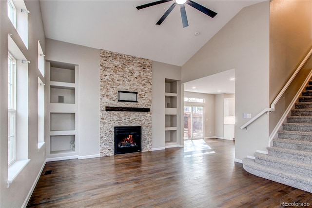 5597 S Buchanan St, Aurora, CO 80016 - unfurnished living room with built in features, a ceiling fan, dark wood-style flooring, stairs, and high vaulted ceiling