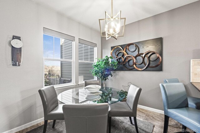 dining space with baseboards and a notable chandelier