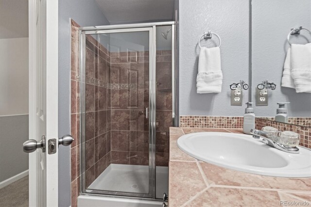 bathroom featuring a sink and a shower stall