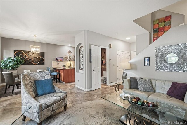 living area featuring an inviting chandelier, baseboards, recessed lighting, and stone finish flooring