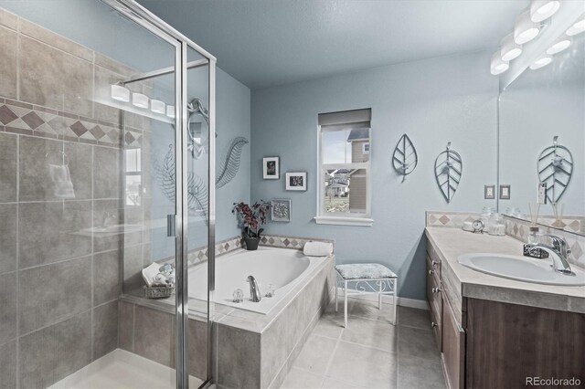 bathroom featuring vanity, baseboards, tile patterned floors, a bath, and a shower stall