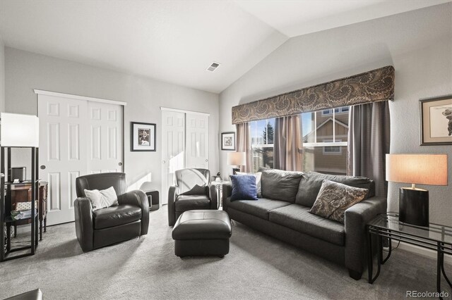 living room featuring visible vents, carpet, and vaulted ceiling