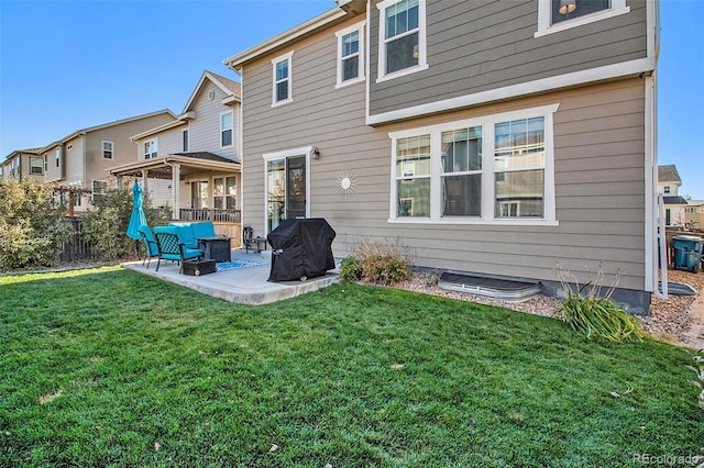 rear view of property with outdoor lounge area, a yard, and a patio