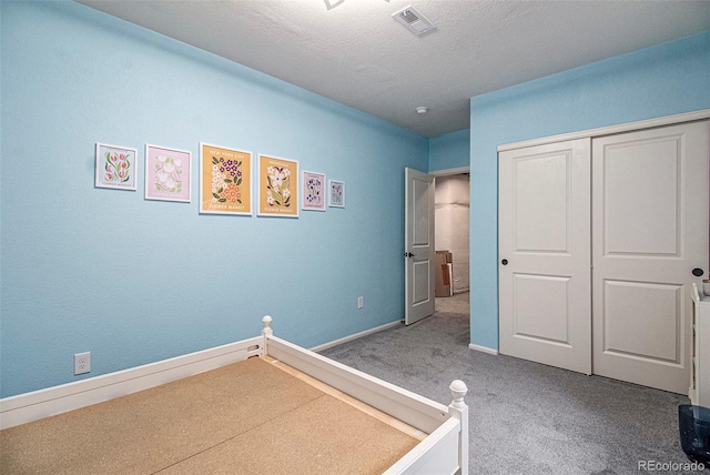 unfurnished bedroom with carpet flooring, a closet, and a textured ceiling