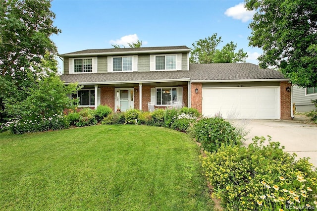 10328 W Crestone Mtn, Littleton, CO 80127 - view of front of home with concrete driveway, a garage, a front yard, brick siding, and a shingled roof