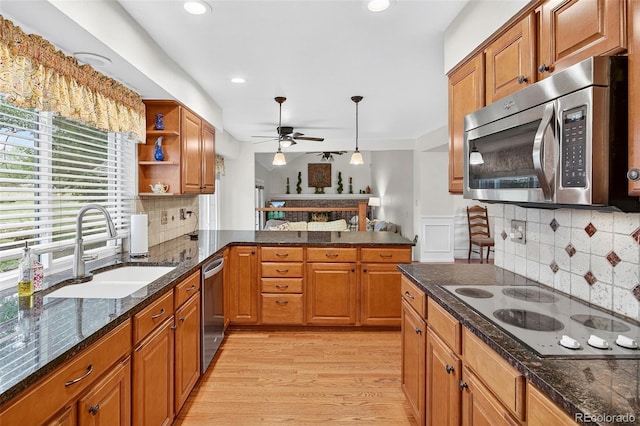 10328 W Crestone Mtn, Littleton, CO 80127 - kitchen with appliances with stainless steel finishes, ceiling fan, decorative backsplash, light wood finished floors, and recessed lighting