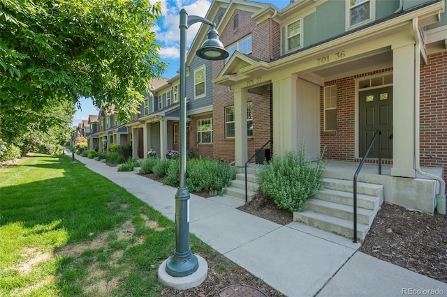 701 N Roslyn St Unit 36, Denver, CO 80230 - entrance to property featuring brick siding, a residential view, a lawn, and a porch