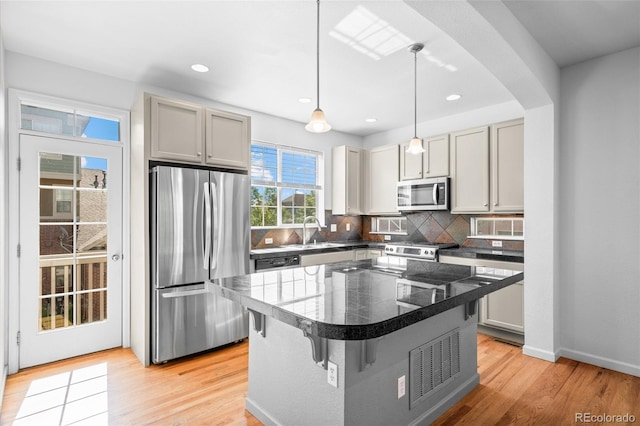 701 N Roslyn St Unit 36, Denver, CO 80230 - kitchen featuring stainless steel appliances, tile countertops, a sink, a kitchen bar, and backsplash