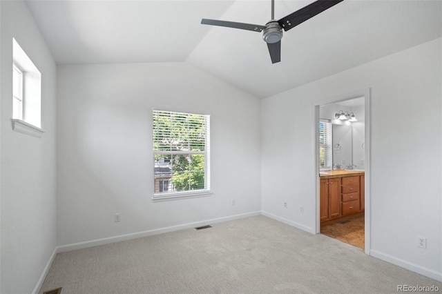 701 N Roslyn St Unit 36, Denver, CO 80230 - unfurnished bedroom featuring multiple windows, light carpet, lofted ceiling, and baseboards