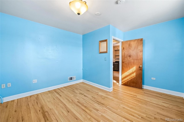 unfurnished bedroom with light wood-style flooring, visible vents, and baseboards