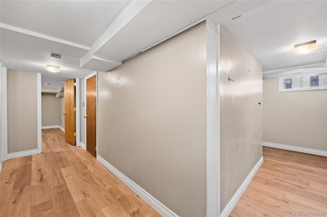 corridor featuring baseboards and light wood finished floors