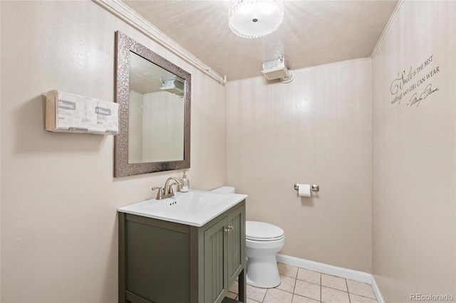 bathroom featuring toilet, ornamental molding, vanity, tile patterned flooring, and baseboards