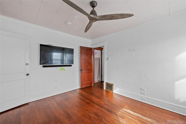 spare room with dark wood-type flooring, visible vents, baseboards, and a ceiling fan