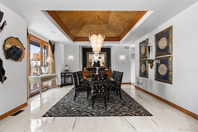 dining room with crown molding, a notable chandelier, and a raised ceiling