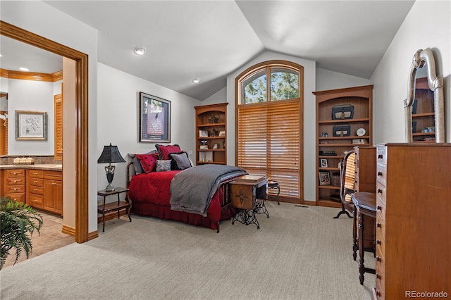 bedroom featuring light colored carpet, ensuite bathroom, and vaulted ceiling