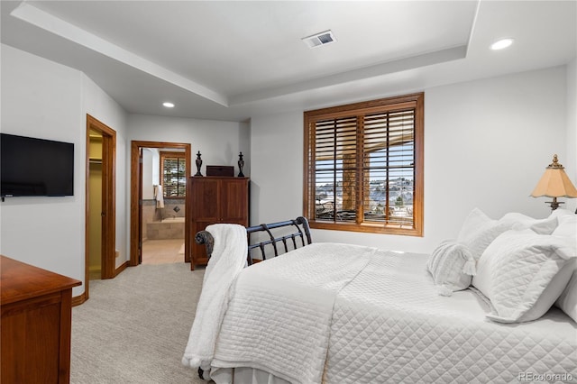 bedroom featuring ensuite bathroom, light colored carpet, and multiple windows