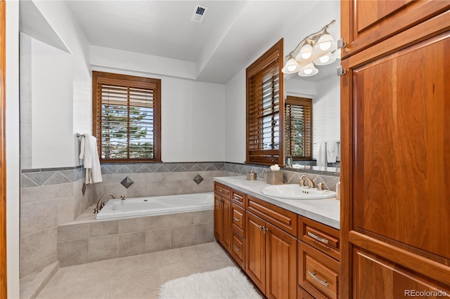 bathroom with a relaxing tiled tub, tile walls, tile patterned floors, and vanity