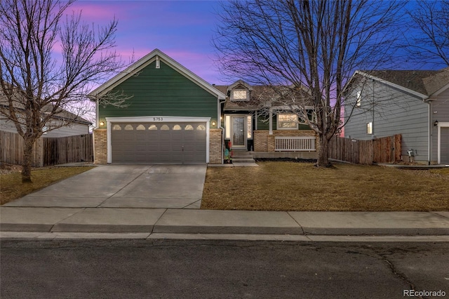 view of front of property with concrete driveway, fence, and brick siding