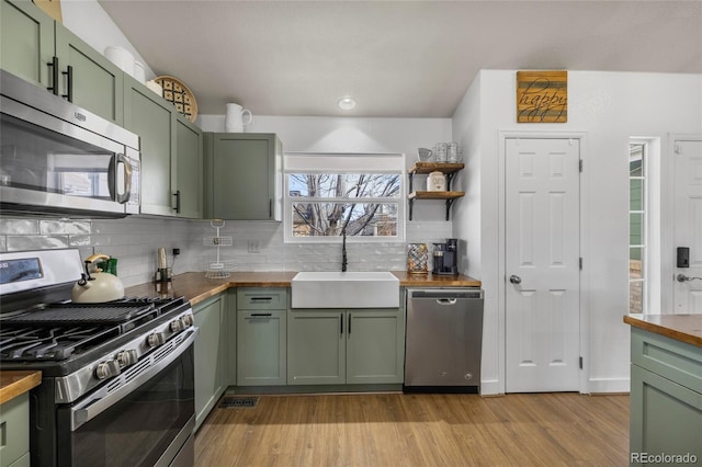 kitchen featuring a sink, stainless steel appliances, and green cabinetry