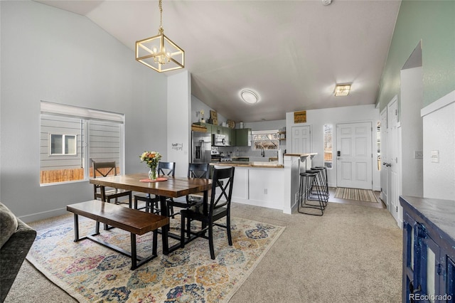 dining room with light colored carpet, baseboards, an inviting chandelier, and vaulted ceiling