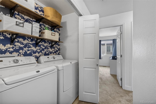 washroom with baseboards, light carpet, separate washer and dryer, and laundry area