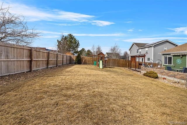 view of yard featuring a fenced backyard and a playground