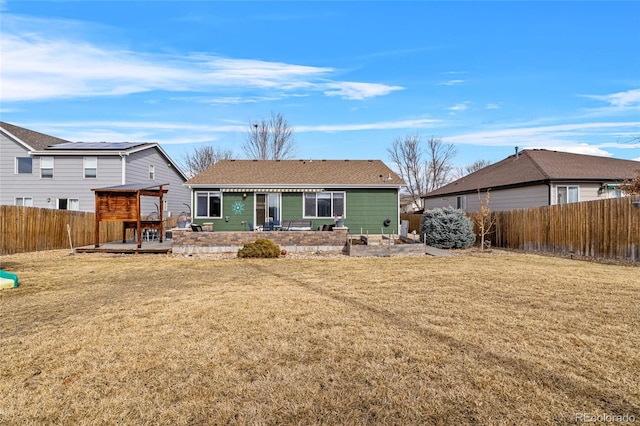 back of house featuring a yard and a fenced backyard