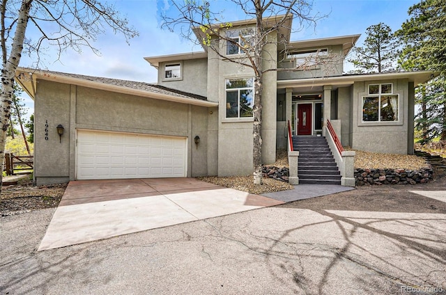 19640 Four Winds Way, Monument, CO 80132 - view of front facade featuring stucco siding, concrete driveway, and a garage