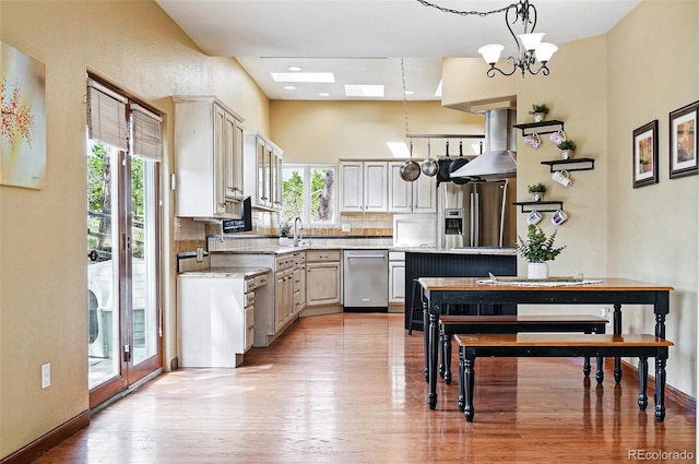 19640 Four Winds Way, Monument, CO 80132 - kitchen with appliances with stainless steel finishes, wall chimney range hood, healthy amount of natural light, and light countertops