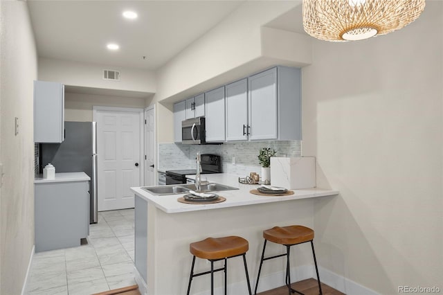 9590 E Florida Ave Unit 1025, Denver, CO 80247 - kitchen with stainless steel microwave, black range with electric cooktop, a peninsula, light marble finish floors, and a breakfast bar