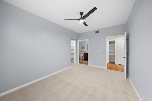 9590 E Florida Ave Unit 1025, Denver, CO 80247 - unfurnished bedroom featuring a spacious closet, a closet, light carpet, baseboards, and connected bathroom