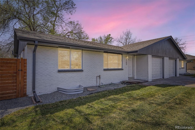 single story home with a front yard, brick siding, driveway, and an attached garage