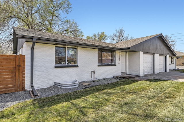 ranch-style home featuring fence, brick siding, an attached garage, and a front lawn