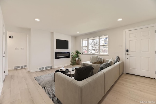 living area featuring light wood-type flooring, baseboards, visible vents, and recessed lighting