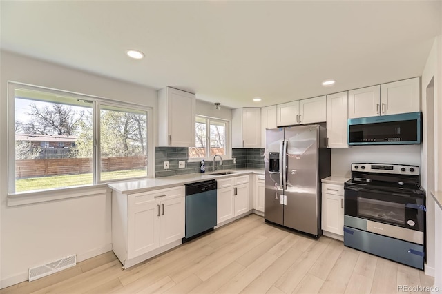 kitchen featuring stainless steel appliances, visible vents, light countertops, and light wood-style flooring