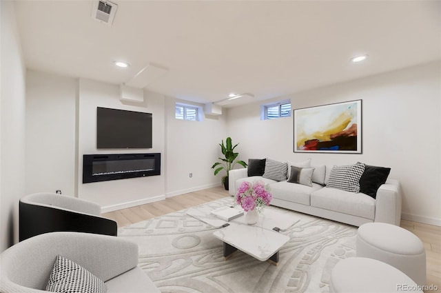 living area featuring visible vents, baseboards, recessed lighting, and wood finished floors