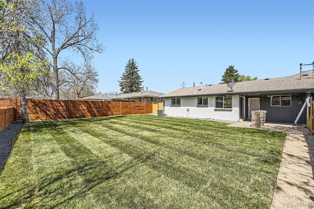 view of yard with central AC, a fenced backyard, and a patio area