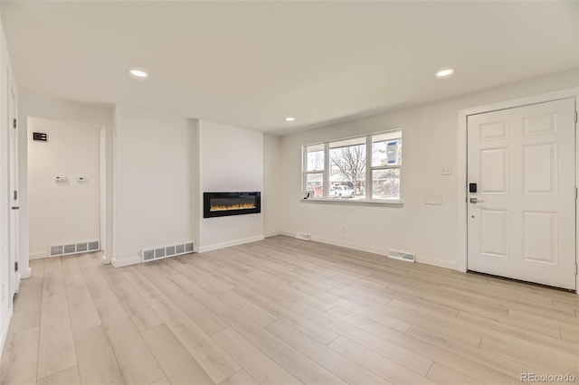 unfurnished living room with light wood-style floors and visible vents