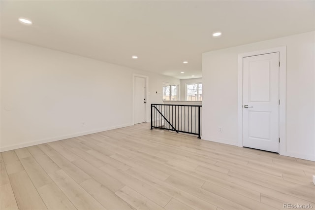 unfurnished room with light wood-style flooring, baseboards, and recessed lighting