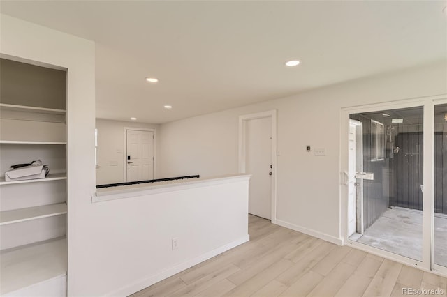 unfurnished room featuring wood finished floors, baseboards, and recessed lighting