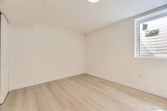 spare room with light wood finished floors and baseboards