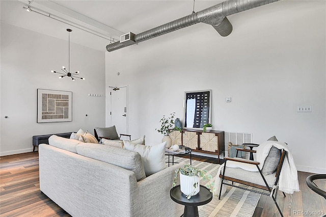 2501 15th St Unit 3F, Denver, CO 80211 - living area featuring a towering ceiling, baseboards, wood finished floors, and a chandelier