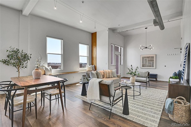 2501 15th St Unit 3F, Denver, CO 80211 - living area with beam ceiling, wood finished floors, a chandelier, baseboards, and a towering ceiling